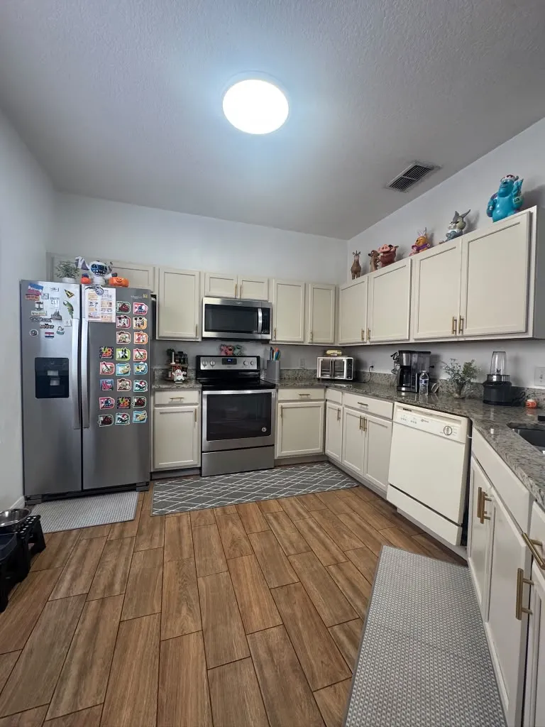 After: the same kitchen with cabinets painted soft cream and brass pulls