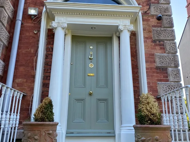 Georgian front door painted soft grey-green, with white columns and trim