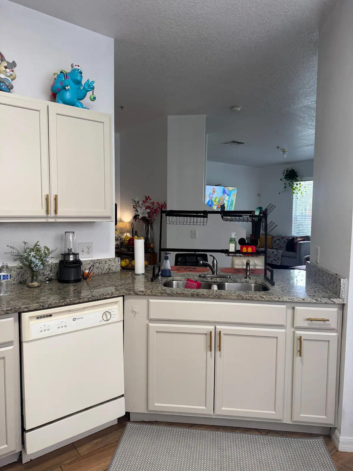 Cream cabinets around the sink with brass pulls