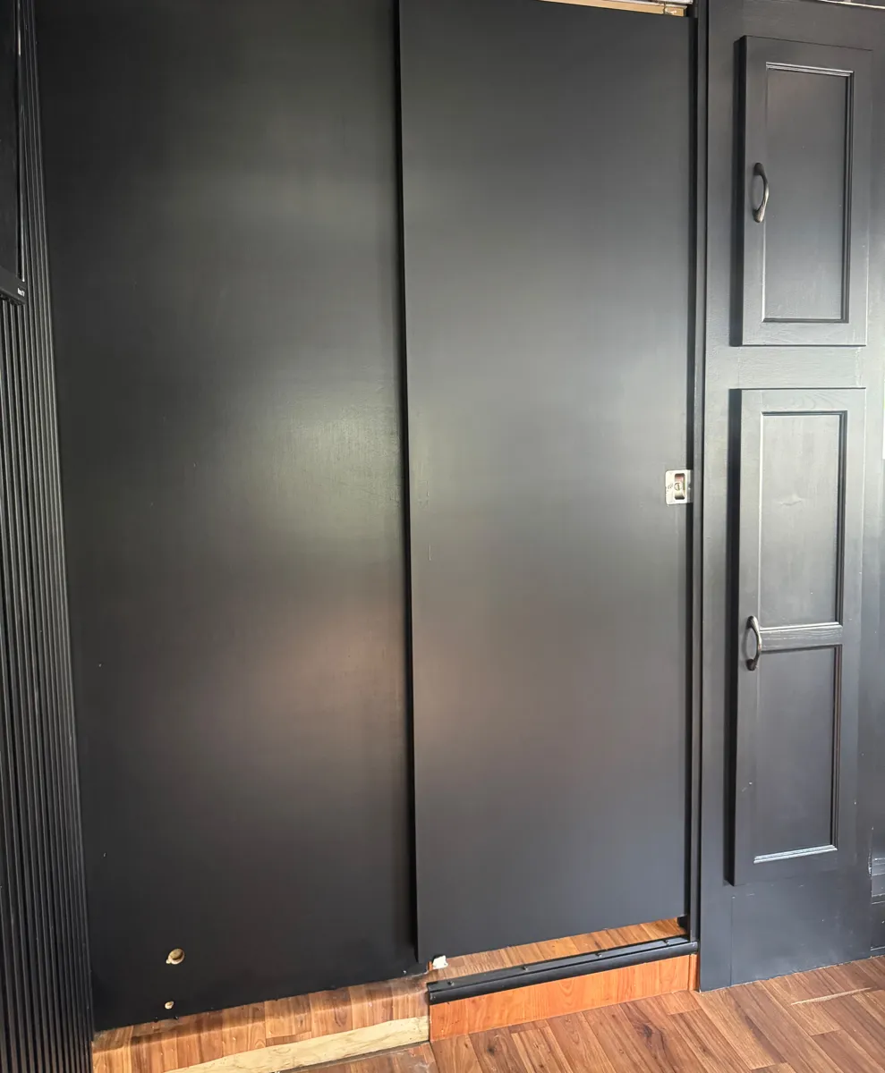 Closet doors and a tall cabinet painted black in the motorhome